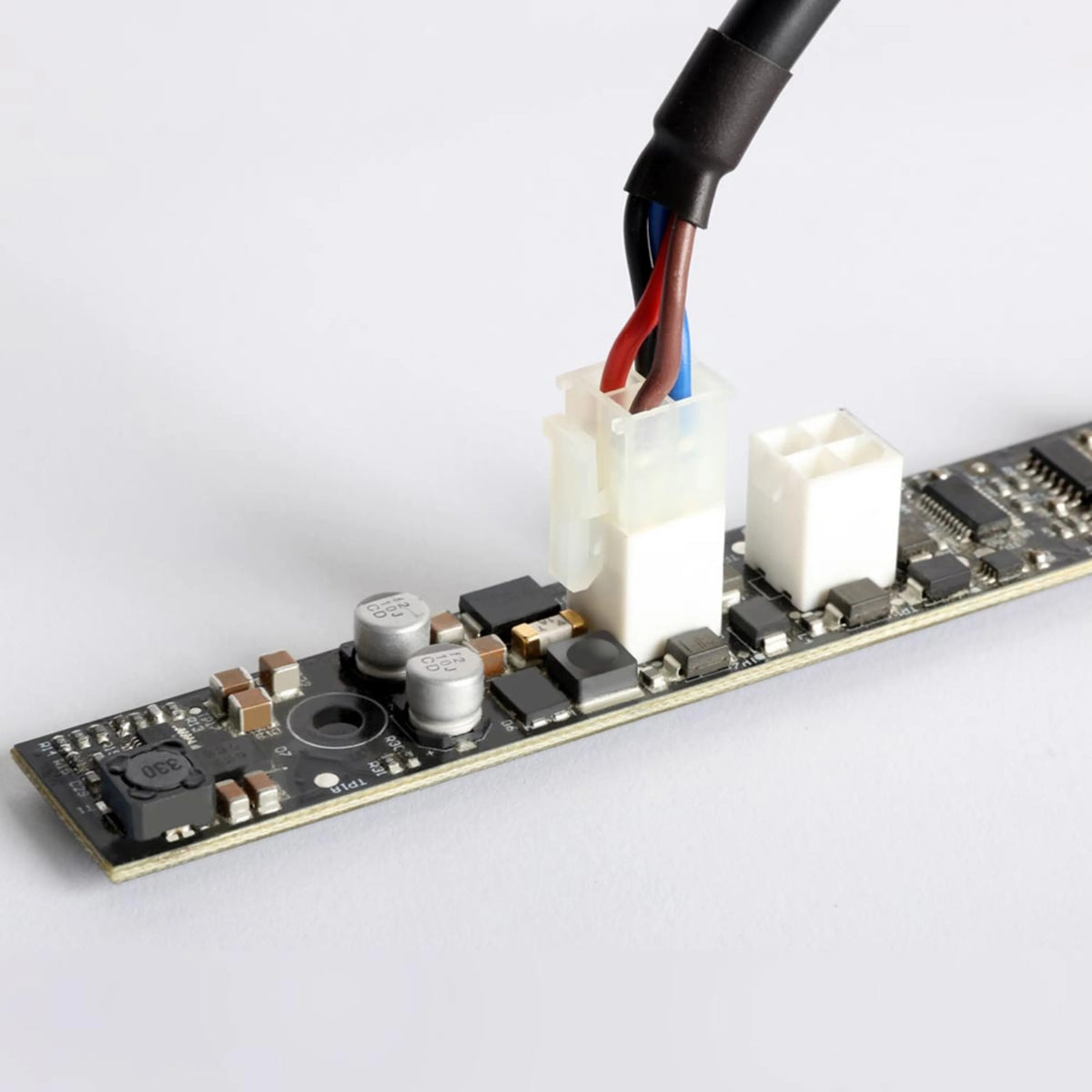 VC-Strip 25 connector detail with multi-conductor power lead plugged into white JST-style header beside spare THRU socket, Martin Lighting
